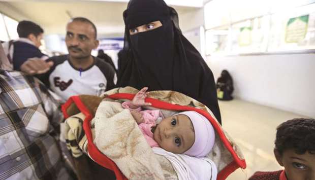 A Yemeni woman carries an ill child as they wait to travel abroad via a UN-sponsored humanitarian air bridge, at the Health Ministry headquarters in the capital Sanaa, yesterday.