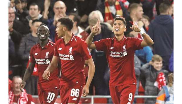 Liverpoolu2019s Roberto Firmino (right) celebrates after scoring their third goal against PSG in Champions League Group C match at Anfield on Tuesday. (AFP)