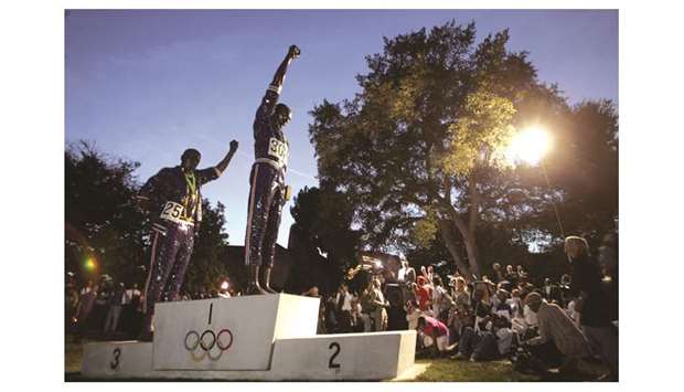 In this October 17, 2005 picture, attendees surround a 20-foot sculpture honouring the protest by San Jose State sprinters Tommie Smith