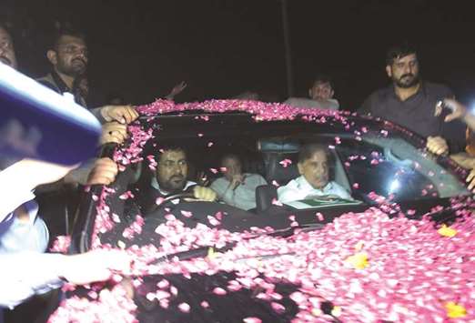 Nawaz Sharif (centre, back) sits in a vehicle alongside his younger brother Shahbaz Sharif, right, following his release from Adiala prison in Rawalpindi yesterday.