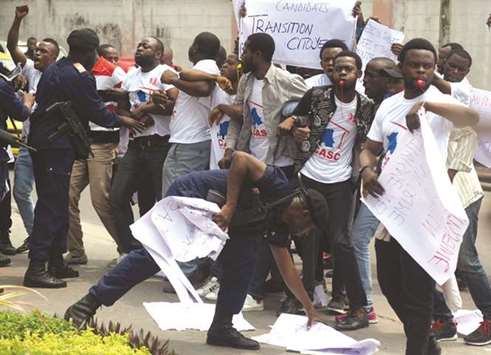 Congolese police officers attempt to disperse members of the Civil Society Action Collective chanting slogans as they protest to demand free fair elections outside government headquarters in Kinshasa.