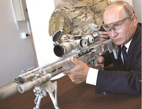 Russian President Vladimir Putin aims a Chukavin sniper rifle SVCh-308 made by Russian firearms maker Kalashnikov Concern at Patriot military theme park outside Moscow.