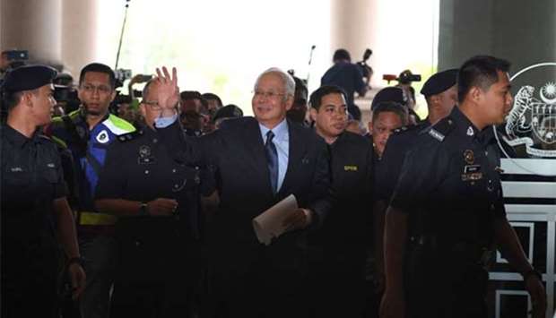 Najib Razak is escorted by police to the court house in Kuala Lumpur on Thursday.