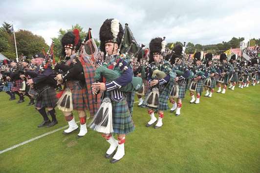 Massed pipe bands parade at the annual Braemar Gathering in Braemar, central Scotland yesterday. The Braemar Gathering is a traditional Scottish Highland Games which predates the 1745 Uprising, and since 1848 it has been regularly attended by the reigning monarch Queen Elizabeth and members of the royal family.