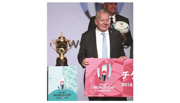 World Rugby chairman Bill Beaumont (foreground) and Japan head coach Jamie Joseph (background) pose for a photo next to the Webb Ellis Cup during a kick-off event to mark a one-year countdown to the 2019 Rugby World Cup in Tokyo yesterday. (AFP)
