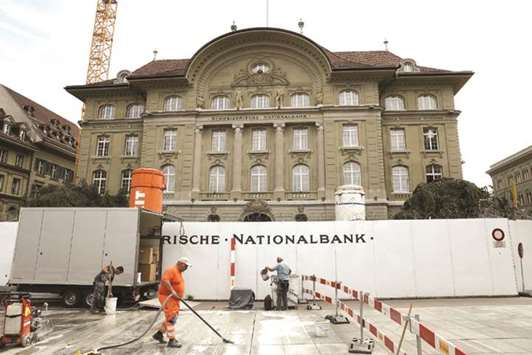 Construction labourers work in front of a hoarding surrounding the Swiss National Bank building in Bern. With the Swiss franc having gained nearly 7% against the euro since April, the SNB forecast inflation would remain limp in 2019 and 2020.