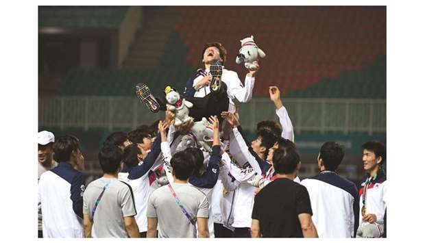 South Koreau2019s players toss their teammate Son Heung-min in the air after the victory ceremony for the menu2019s football competition at the 2018 Asian Games in Bogor, Indonesia, yesterday. (AFP)
