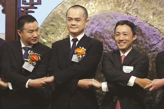 Wang Xing, co-founder and chairman of Chinau2019s Meituan Dianping (centre), attends the debut of the company at the Hong Kong exchange yesterday. The company rose 5% on debut in Hong Kong, valuing  firm at about $55bn and sending a positive signal to companies lining up to list in the financial hub.