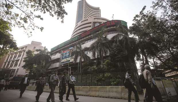 People walk by the Bombay Stock Exchange building in Mumbai. The BSE Sensex closed down 279.62 points to 37,121.22 yesterday.