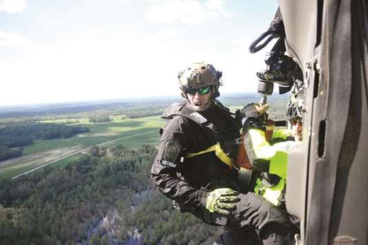 This picture taken on Wednesday shows an officer with the Pennsylvania Helicopter Aquatic Rescue Team prepares to conduct an aerial rescue on a hoist from a Pennsylvania National Guard Black Hawk helicopter in Nichols, South Carolina.