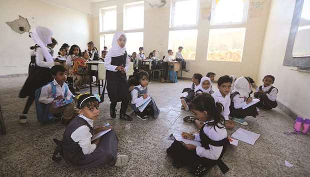 Yemeni students study at a classroom on the first day of the new academic year on September 16, 2018, at a school that was damaged last year in an air strike.