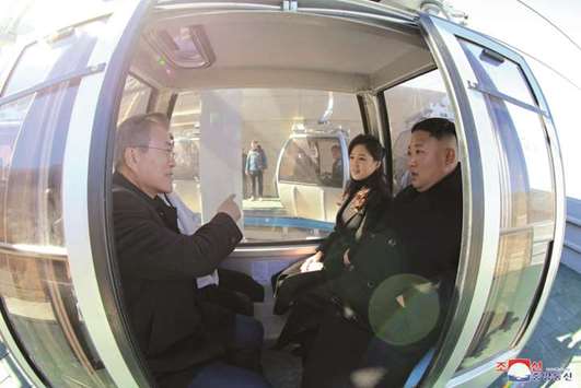 South Korean President Moon Jae-in, North Korean leader Kim Jong-un and his wife Ri Sol Ju sit inside a cable car at Mt Paektu, North Korea.