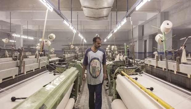 A worker inspects fabric on looms at a textile manufacturer in Karachi. After announcing Rs44bn subsidy to export-oriented industry particularly for textile industry, the Imran Khan government has decided to jack up the exports of the country to $27bn from existing $23.4bn in nine months of the ongoing fiscal 2018-19.