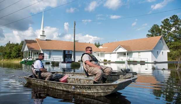A South Carolina Law Enforcement agent, right, and a Department of Natural Resources officer look for stranded residents in floodwaters caused by Hurricane Florence in front of McNeil Chapel Missionary Baptist Church near the Todd Swamp, South Carolina.