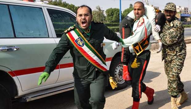 An Iranian soldier carrying an injured comrade at the scene of an attack on military parade. AFP/ISNA