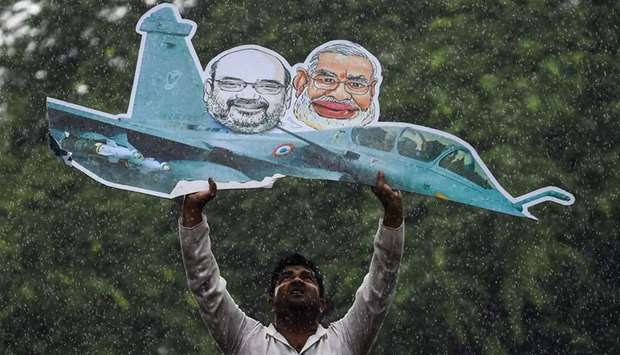 A supporter of the Indian Youth Congress holds a model of a Rafale fighter jet during a protest in N