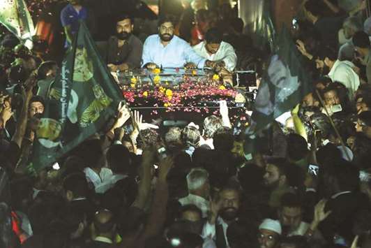 This picture taken on September 19 shows supporters of Nawaz Sharif showering rose petals on a car carrying him and his daughter Maryam after their release from Adiala Jail in Rawalpindi.