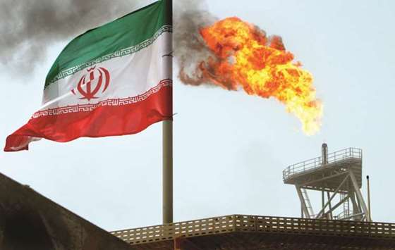 A gas flare on an oil production platform in the Soroush oil fields is seen alongside an Iranian flag (file). Oil accounts for nearly 80% of Iranu2019s tax revenue, according to the International Monetary Fund, making petroleum the countryu2019s economic lifeblood. As oil exports have plunged, Iranu2019s currency has dived 60% on the unofficial market, pushing up inflation.