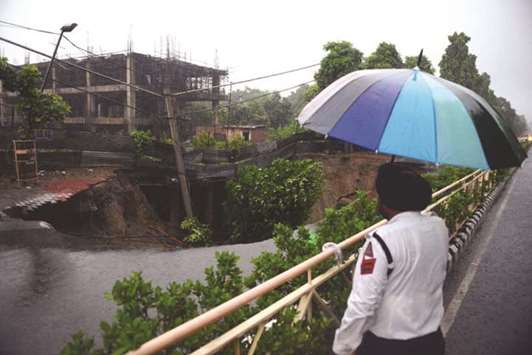 A police officer looks at a road which caved in due to heavy rains in Amritsar, Punjab, yesterday.