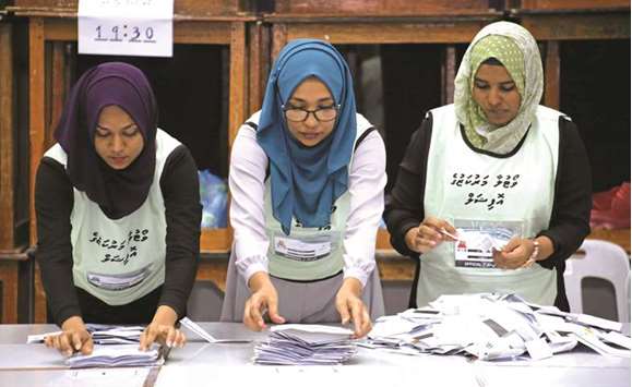 Maldives election commission officials prepare ballot papers for counting votes at a polling station at the end of the presidential election day in Male yesterday.