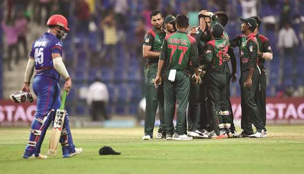 Bangladesh team (right) celebrate their victory over Afghanistan in the Asia Cup Super Four match in Abu Dhabi yesterday. (AFP)
