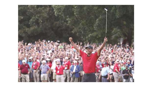 Tiger Woods celebrates making a par on the 18th green to win the Tour Championship at East Lake Golf Club in Atlanta on Sunday.