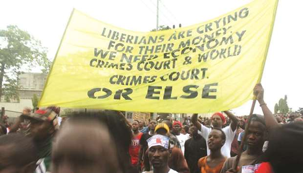 Liberian demonstrators hold a banner during a protest in Monrovia yesterday.
