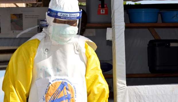 A medical worker wears a protective suit as he prepares to administer Ebola patient care at The Alli