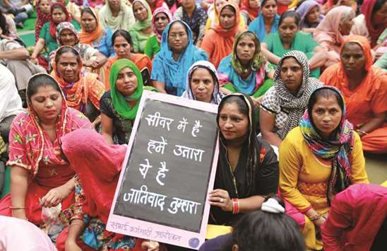Family members of sanitation workers attend a protest against the rising deaths of people cleaning sewers, in New Delhi yesterday.