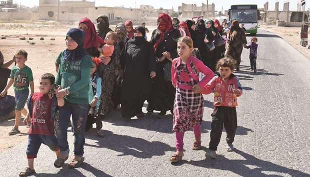 Syrians arrive at the Abu Duhur crossing on the eastern edge of Idlib province yesterday, as they cross from rebel-held areas to regime-held areas.