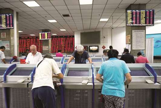 Investors look at computer screens showing stock information at a brokerage house in Shanghai. The Composite index closed down 0.3% to 2,789.04 points yesterday.
