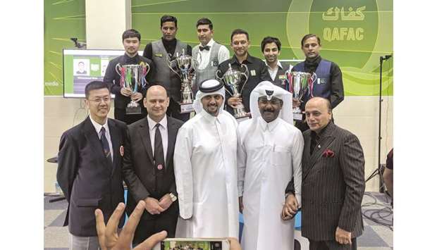 Asian 6 Red Championship winner Thanawat Tirapongpaiboon (background, left) of Thailand, runner-up Mohamed Bilal (background, right) of Pakistan, Asian Team Snooker Championship winners Mohamed Asif (background, second from left) and Babar Masih (background, third from left), runners-up Pankaj Advani (background, second from right) and Manan Chandra (background, third from right) pose with International Billiards and Snooker Federation (IBSF) president Mubarak al-Khayarin (foreground centre), Asian Confederation of Billiard Sports (ACBS) president Mohamed Salem al-Nuaimi (foreground, second from right) and other officials yesterday.