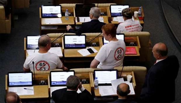 Russian Communist Party deputies Valery Rashkin and Denis Parfyonov wear T-shirts protesting against the pension reform, which envisage raising the retirement age, during a vote session at the State Duma