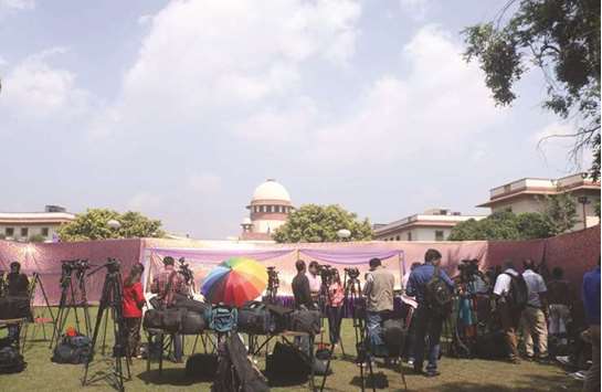 Journalists wait outside the Supreme Court ahead of a ruling on the Aadhaar Act, in New Delhi yesterday.