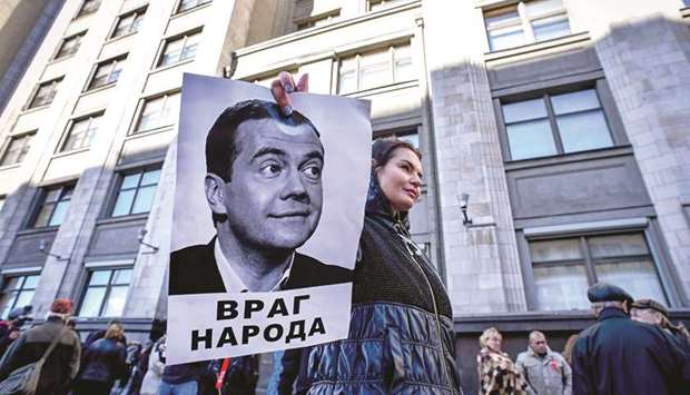 A protester holds a picture of Russian Prime Minister Dmitry Medvedev bearing an inscription reading u2018An enemy of peopleu2019 during a rally against pension reforms in front of the State Duma in Moscow.