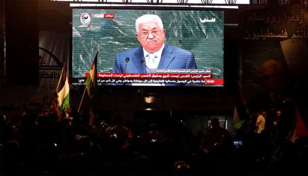 Palestinians watch a television broadcast of President Mahmoud Abbas's speech at the United Nations General Assembly