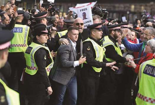 Stephen Christopher Yaxley-Lennon, former leader of the right-wing EDL (English Defence League) is escorted through the crowds as he arrives at The Old Bailey in central London yesterday.