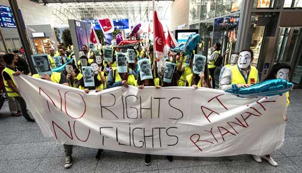 Employees of Irish airline Ryanair hold a banner reading ,No Rights-No Flights at Ryanair, and wearing masks depicting Ryanair CEO Michael O'Leary during a strike at the airport in Frankfurt am Main, western Germany.