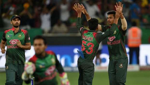 Bangladesh cricketer Mustafizur Rahman (R) celebrates with teammates after he dismissed Indian batsman Mahendra Singh Dhoni during the final one day international (ODI) Asia Cup cricket match between Bangladesh and India