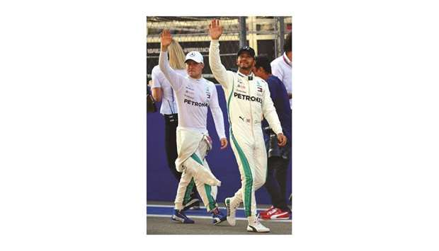 Pole position winner Mercedesu2019 Finnish driver Valtteri Bottas (left) and second positioned British driver Lewis Hamilton gesture after the qualifying session for the Russian Grand Prix in Sochi yesterday. (AFP)