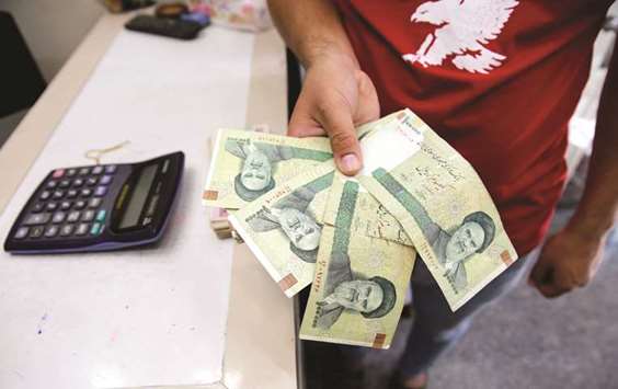 A vendor inspects Iranian rials at a currency exchange shop in Baghdad (file). The currency has lost approximately 75% of its value so far this year.