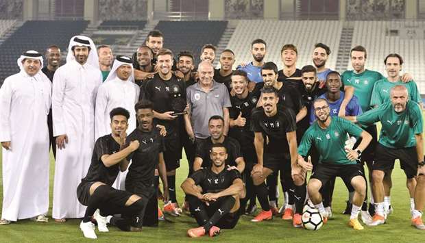 Al Sadd players and officials gather for a photograph during a training session ahead of the AFC Champions League match against Iranu2019s Persepolis yesterday. The club presented a Best Player of the Month memento to its Spanish player Gabi. PICTURE: Noushad Thekkayil