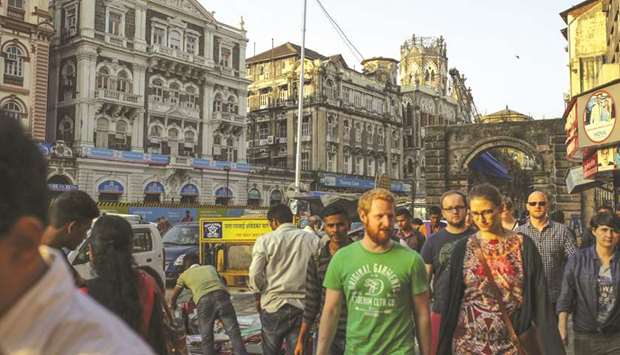 Pedestrians walk past a roadside market in Mumbai. Indiau2019s world-beating economic growth is running up against some big risks: high oil prices, emerging market stress as the era of easy money draws to a close, and policy paralysis in the run-up to next yearu2019s federal election.