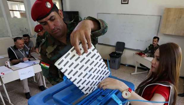 A member of the Kurdish Peshmerga forces casts his ballot at a polling station for parliamentary election in Arbil