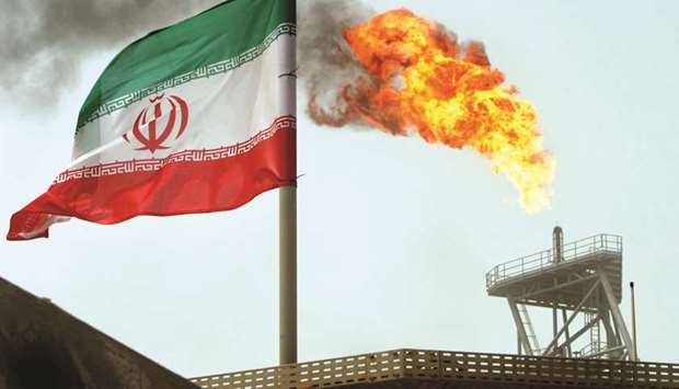 A gas flare on an oil production platform in the Soroush oil fields is seen alongside an Iranian flag in this file picture. Iranu2019s oil exports are tumbling again as the countryu2019s key buyers in Asia take fewer cargoes in the weeks before US sanctions take full effect.