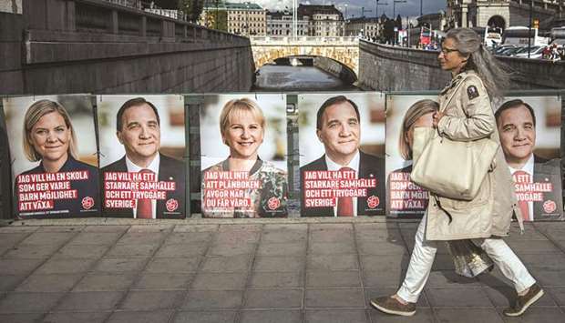 A woman walks next to election posters of the leader of the Social Democrats and Swedish Prime Minister Stefan Loefven, Swedish Minister for Finance Magdalena Andersson (left) and Swedenu2019s Foreign Minister Margot Wallstrom in Stockholm. The general elections in Sweden will take place on September 9.