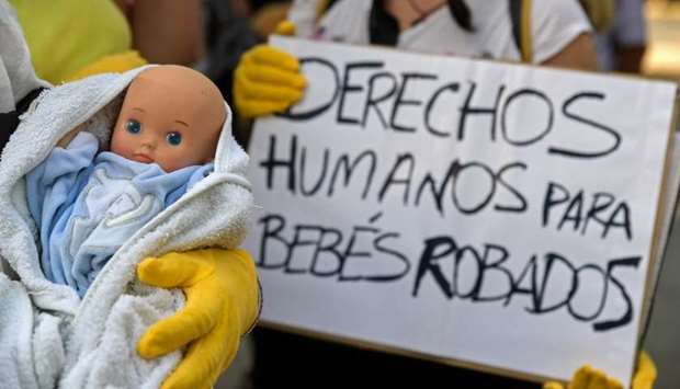 Demonstrators hold baby dolls and placards reading ,Human rights for stolen babies, outside a provincial court in Madrid, on the first day of the first trial over thousands of suspected cases of babies stolen from their mothers during the Franco era. June 26, 2018 file photo.
