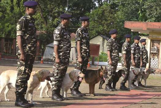 Personnel of the Sashastra Seema Bal (SSB) or Armed Border Force, stand next to their dogs prior to the start of a dog show organised at the Siliguri SSB frontier in Ranidanga, on the outskirts of Siliguri yesterday. Seven dogs performed in the show where the animals displayed various skills including detection of explosives.