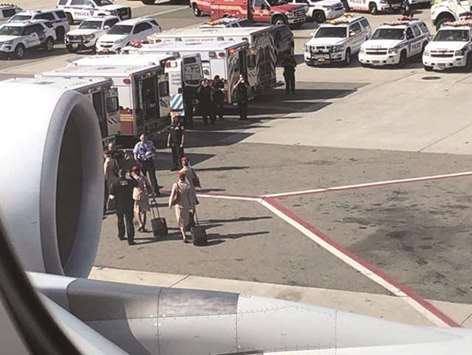 Air cabin crew members and the emergency services are seen leaving the plane, after the passengers were taken ill on a flight from Dubai to New York at JFK Airport yesterday.