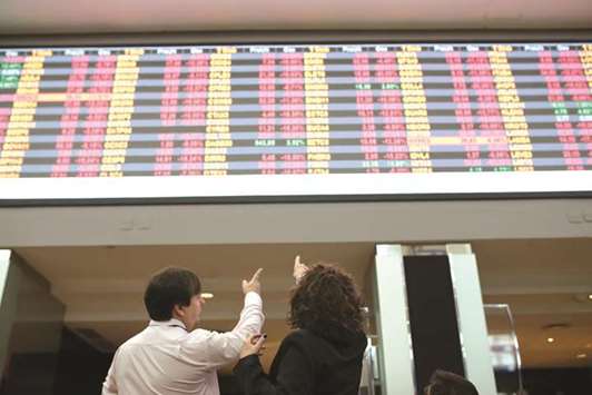 Visitors point towards electronic board displaying stock activity at the Brasil Bolsa Bacao (B3) stock exchange in Sao Paulo (file). One of Brazilu2019s best performing funds has an all-in bet at a time when most investors are dumping the countryu2019s assets.